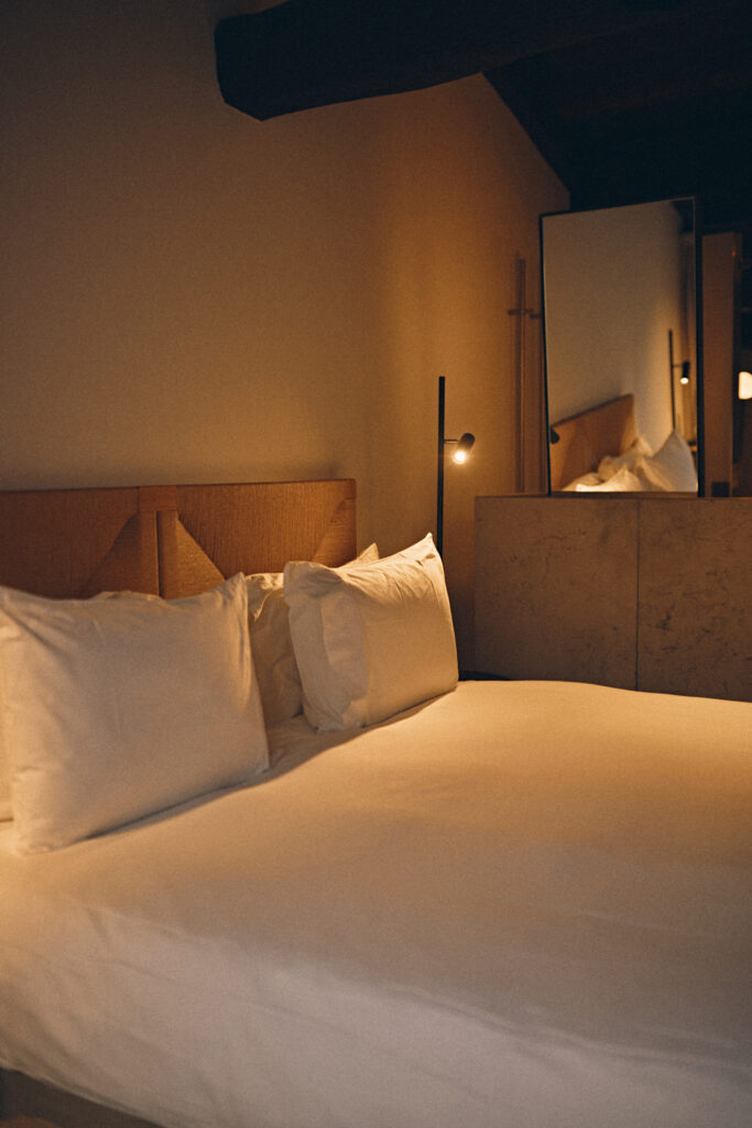 Cama e iluminación cálida en habitación del Nobis Hotel Palma con diseño contemporáneo